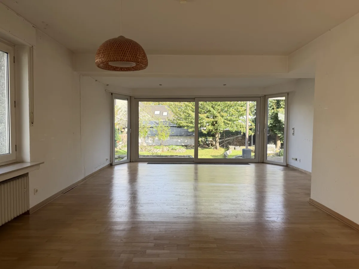 Wohnzimmer mit großer Fensterfront zum Garten